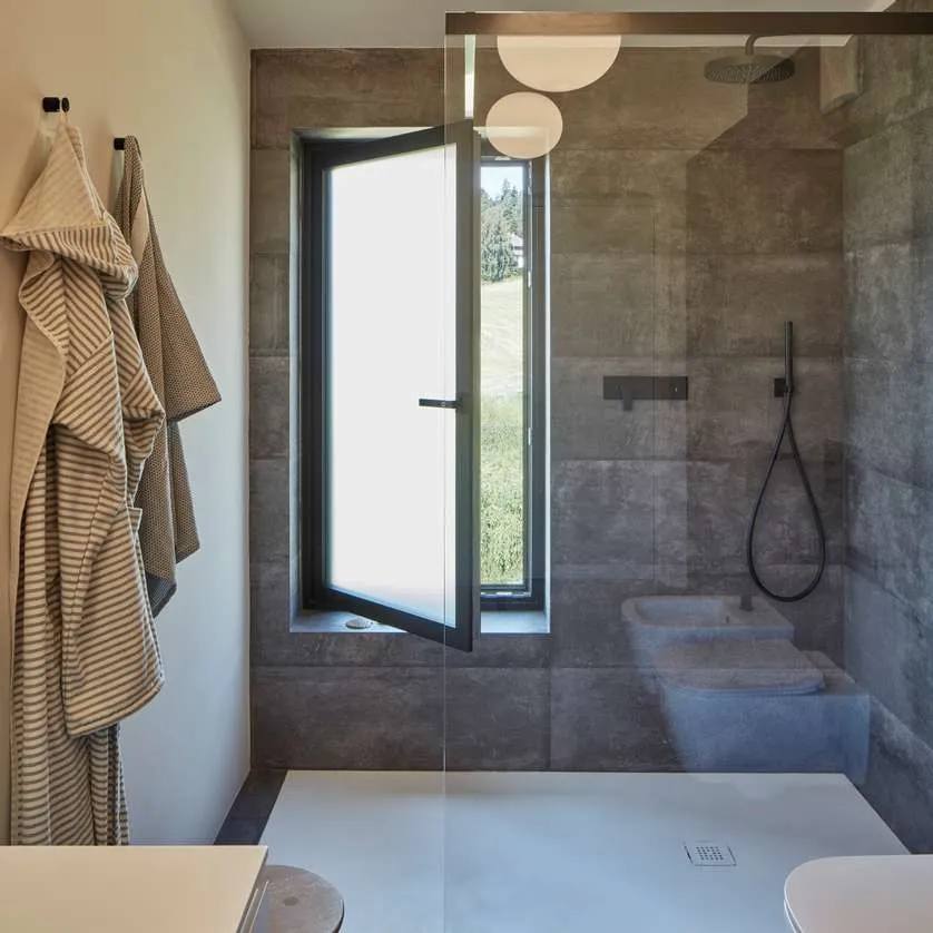 Salle de bains moderne avec fenêtre oscillo-battante entrouverte pour l'aération